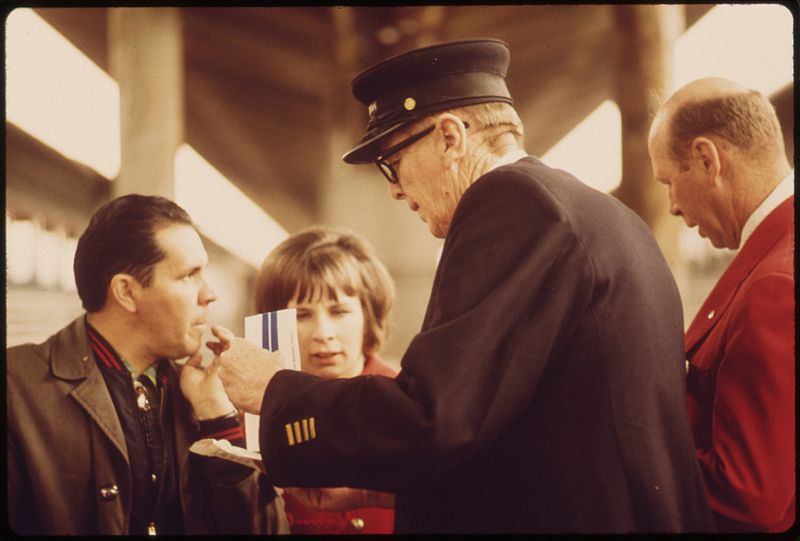 File:CONDUCTOR AND AMTRAK EMPLOYEE (IN RED BLAZER AT RIGHT) ANSWER QUESTIONS BY PASSENGERS CONCERNING SCHEDULES. AMTRAK... - NARA - 555966.jpg