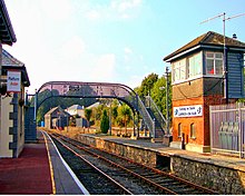 Gare de Carrick-on-Suir, exploitée par la compagnie Iarnród Éireann, avec signalisation bilingue.