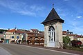 Blick auf eine kleine Kapelle mit Glastür auf einer Brücke.