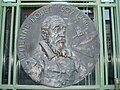 Медаль на честь друкаря і атеїста Етьєна Доле, на тлі двері Публічної бібліотеки в Тулузі.
