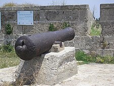 Eine Kanone, die an der Stadtmauer von Akko in der Nähe des Gedenkzeichens zu Ehren von Chaim Farhi montiert ist