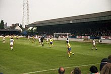 Oxford United (yellow and blue) playing a home match at the Manor Ground in 1980 London Road, Manor Ground, Oxford.jpg