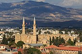 Photo d'une église en pierre transformée en mosquée à Nicosie, drapeau turc flottant et ciel bleu, un minaret a été ajouté à l'édifice après la conquête de l'île par les Ottomans.