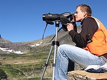 Scanning the cliffs near Logan Pass for mountain goats as part of the Glacier National Park Citizen Science Program Scanning the cliffs near Logan Pass for mountain goats (Citizen Science) (4427399123).jpg