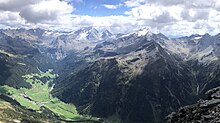 Schneebiger Nock (rechts der Mitte zwischen Gelttal (rechts) und Bachertal (links)), davor Rein in Taufers (links vorn) mit Reintal, im Hintergrund Großer Rotstein, Mulle, Winkelspitze, Lenkstein, Barmer Spitze, Hochgall, Hochgallhütte, Wildgall, Hochflachkofel (links vom Schneebigen Nock mit Rieserferner) sowie Gelttalspitze, Rieserfernerhütte, Schwarze Wand und Wasserkopfspitze (rechts vom Schneebigen Nock), direkt vor dem Schneebigen Nock der Gatternock