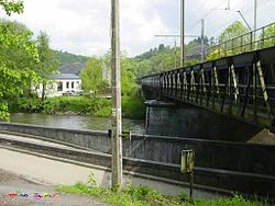 Een spoorbrug (met looprand) over de Ourthe met op de achtergrond Sy