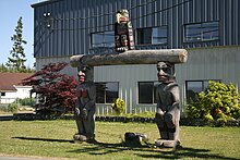 A welcome pole in front of U'gwamalis Hall, the Band Office for the Kwakiutl First Nation.