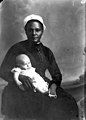 White-capped nurse holding an infant (3248110220).jpg