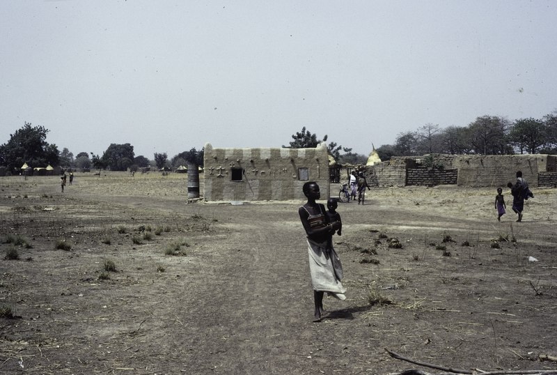 File:ASC Leiden - F. van der Kraaij Collection - 07 - 096 - Une jeune femme porte un enfant sur un bras devant un bâtiment carré - Mossi Plateau, Plateau-Central, Burkina Faso, 1982.tif
