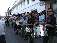 Musika-banda danborrak, txindatak eta beste instrumentu batzuk jotzen.