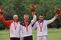 Three men holding bouquets in their hands and Olympic medals around their necks