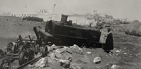 A man inspects the derailed Decauville locomotive belonging to La Compagnie Marocaine in 1907. Derailed locomotive in Casablanca 1907.jpg