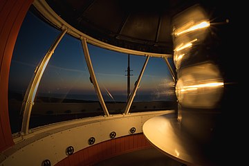 Działający aparat optyczny latarni morskiej Stilo po zachodzie słońca