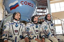 Expediția 36 de membri ai echipajului de rezervă în fața machetei navei spațiale Soyuz TMA din Star City, Rusia.jpg