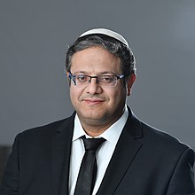 Ben-Gvir smiling, wearing a suit and kippah