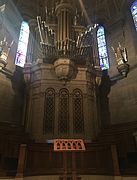 Choir pews located behind the altar, with the organ pipes above them