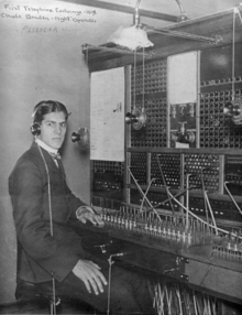 Telephone operator with a single head-mounted telephone-receiver ("headphone"), 1898 Night telephone operator 1898.png