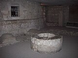 Photo du puits de l'œuvre situé dans la chapelle absidiale et une niche engrillagée dans le mur, qui contient le coffret de plomb renfermant le cœur du roi de France Charles V, retrouvé lors des fouilles de 1931