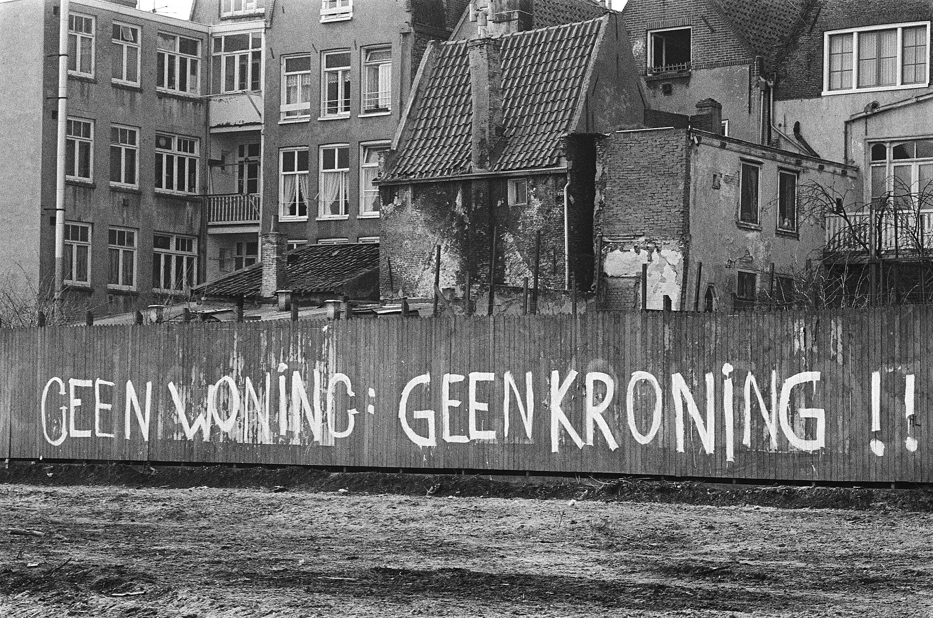 https://upload.wikimedia.org/wikipedia/commons/thumb/5/56/Tekst_Geen_woning%2C_geen_kroning_op_schutting_Haarlemmer_Houttuinen%2C_Bestanddeelnr_930-7455.jpg/1920px-Tekst_Geen_woning%2C_geen_kroning_op_schutting_Haarlemmer_Houttuinen%2C_Bestanddeelnr_930-7455.jpg