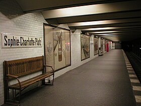 Banchina della stazione con manifesti storici.