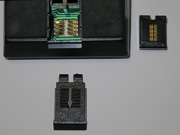 TI-59 programmable calculator with ROM software library module at right, showing gold-plated contacts. Via the modules, software for a broad spectrum 