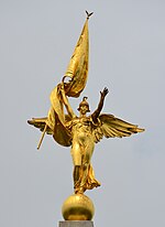 Estátua de ouro de uma figura feminina de anjo com bandeira