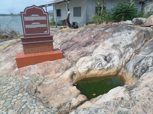 A plaque next to the Batu Pahat Well depicting the town's origin.