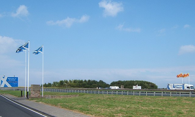 The A1 road crossing the border between Scotland and England. Entry to Scotland is marked by three Scottish saltires and entry into England is marked 