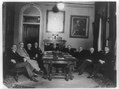 Charles Evans Hughes seated at head of table, with eight other men around the table in the Diplomatic Room of the State Department LCCN89709659.tif