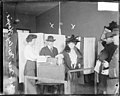 Cook County State's Attorney, Maclay Hoyne, standing by a ballot box with his wife in a polling place.jpg
