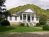 old white one-story house with four columns in front