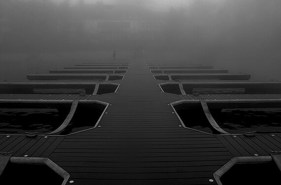 A small boat dock alongside the water in Lake Arrowhead, California, USA on a foggy day.