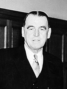 Black and white photograph of Dr Henry Yellowlees, a white man with widow’s peak and dark slicked-back hair, wearing a suit and tie.