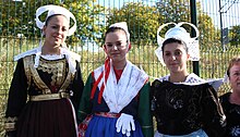 Photo en buste de trois jeunes filles en costume traditionnel breton.