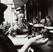 Carl Zuckmayer auf einer Café-Terrasse, Glas erhoben, vor 1962