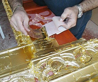 22k gold leaf applied with an ox hair brush during the process of gilding