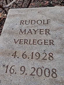 Zu sehen ist ein Grabstein aus hellem Sandstein, beschriftet mit Rudolf Mayer, Verleger, 4.6.1928 bis 16.9.2008