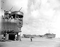 LST-325 (left) and LST-388 unloading while stranded at low tide during resupply operations, 12 June 1944