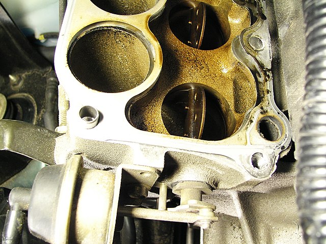 Lower intake manifold on a 1999 Mazda Miata engine, showing components of a variable length intake system.