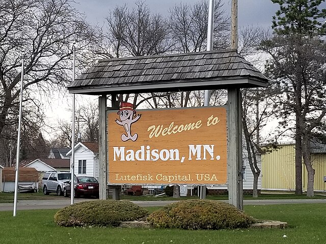 Sign welcoming visitors to Madison featuring a cartoon cod