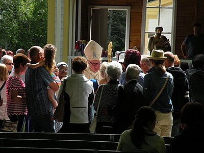 A priest talking to people after mass.