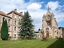 Photo d'un bâtiment imposant de plusieurs étages et d'une chapelle.