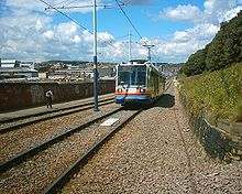 Siemens-Duewag Supertram 122, operating the Purple Route to Herdings Park, on the permanent way leaving Sheffield station for Sheffield College (Granville Road) in July 2004 Supertram Sheffield Station 05-07-04.jpg