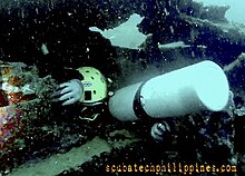 An advanced sidemount diver conducting overhead penetration in a shipwreck, using multiple stages and passing tight restrictions. Technical wreck penetration training course.jpg