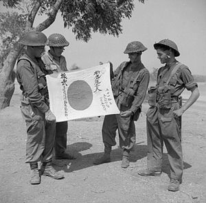 Photograph of four British soldiers examining s captured Japanese flag