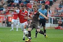 Halstenberg fighting for the ball with Union Berlin's Torsten Mattuschka in August 2013. Torsten Mattuschka (l.) im Duell mit Marcel Halstenberg (r.); Schiedsrichter Felix Brych beobachtet die Szene. (10295683355).jpg