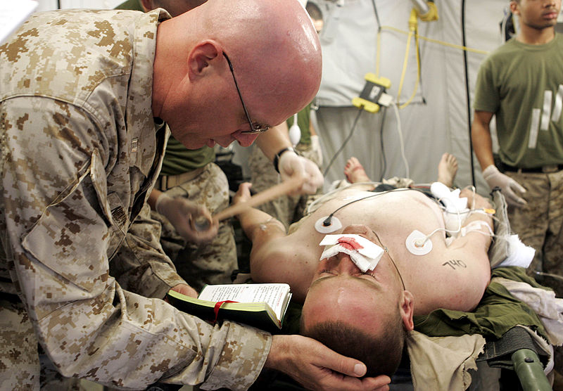 File:US Navy 041116-M-0000G-003 U.S. Navy Lt. Kenneth W. Nielson, a Catholic chaplain assigned to the 1st Force Service Support Group, say a prayer for a Marine patient being treated.jpg