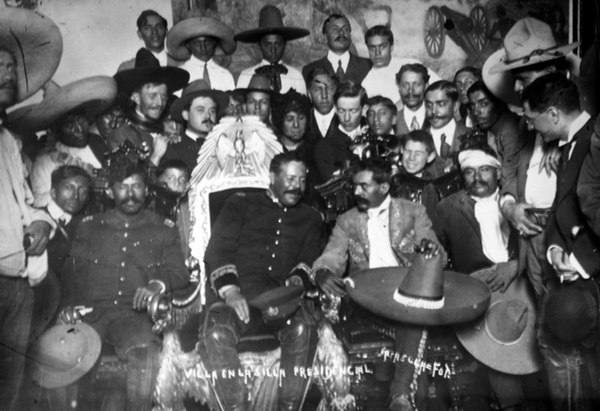 Photograph of Pancho Villa seated in the presidential chair, together with Emiliano Zapata