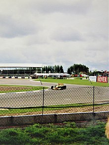 Foto di una pista da corsa su cui corre una monoposto gialla