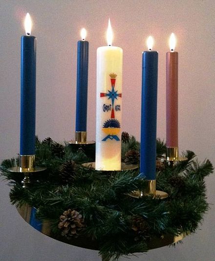 Advent wreath with three blue candles and one rose candle surrounding the central Christ Candle